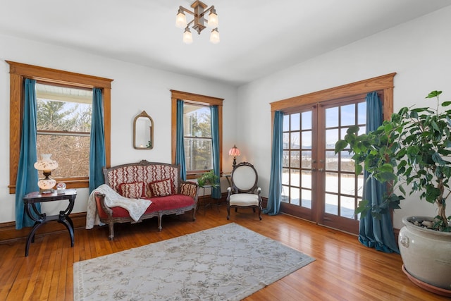 living area with plenty of natural light, wood finished floors, and french doors