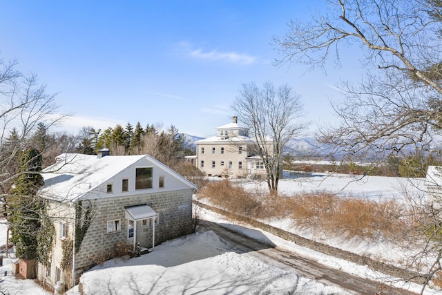 snow covered property featuring a chimney