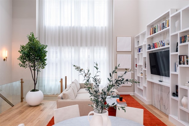 living room with hardwood / wood-style flooring and a towering ceiling