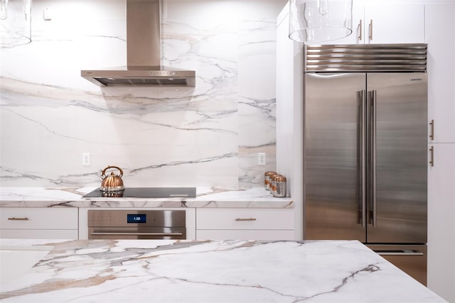 kitchen with stainless steel appliances, tasteful backsplash, light stone counters, white cabinets, and island exhaust hood