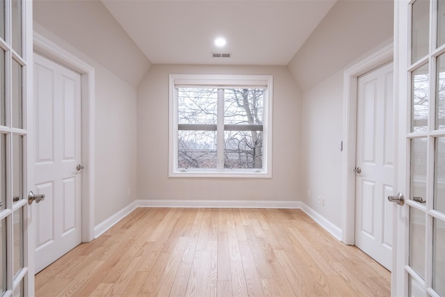 interior space with lofted ceiling and light hardwood / wood-style floors