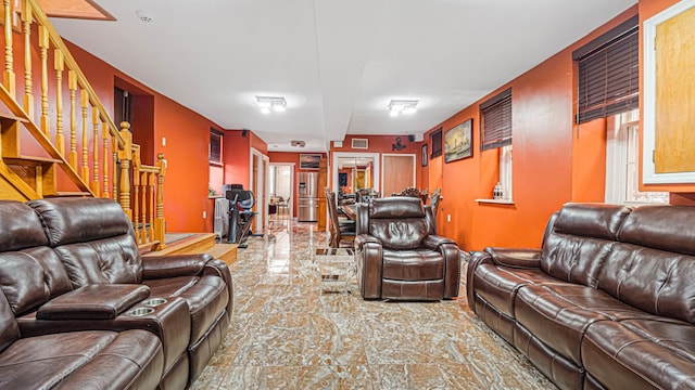 living area with stairs, stone finish flooring, and visible vents