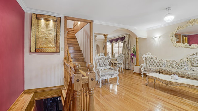 interior space with ornamental molding, arched walkways, decorative columns, and wood finished floors