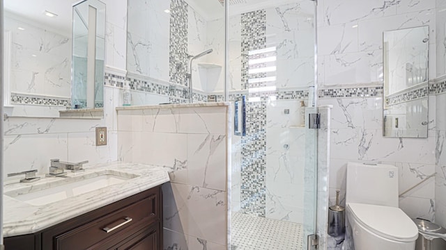 bathroom with toilet, a shower stall, tile walls, and vanity