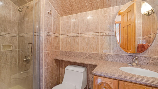 bathroom with toilet, a stall shower, vanity, and tile walls