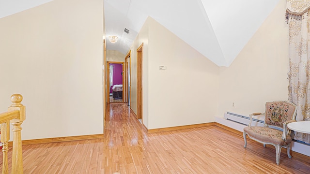 hallway with light wood-type flooring, lofted ceiling, a baseboard heating unit, and baseboards