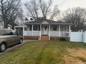 view of front of home with covered porch and a front lawn