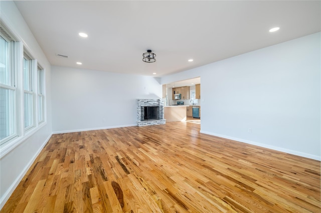 unfurnished living room featuring sink and light wood-type flooring