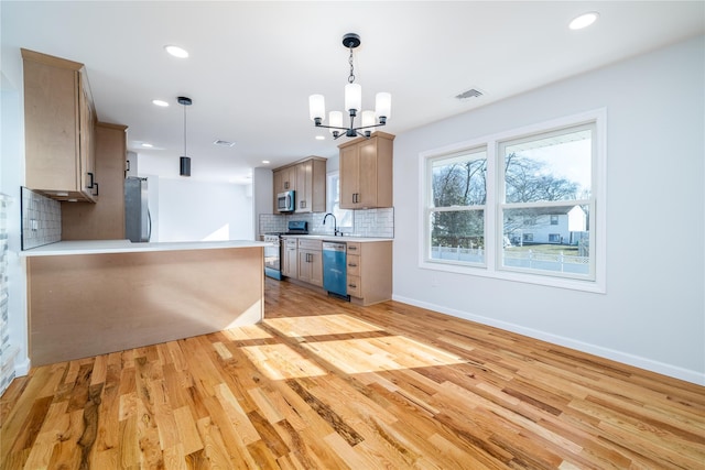 kitchen with tasteful backsplash, hanging light fixtures, light wood-type flooring, light brown cabinets, and stainless steel appliances