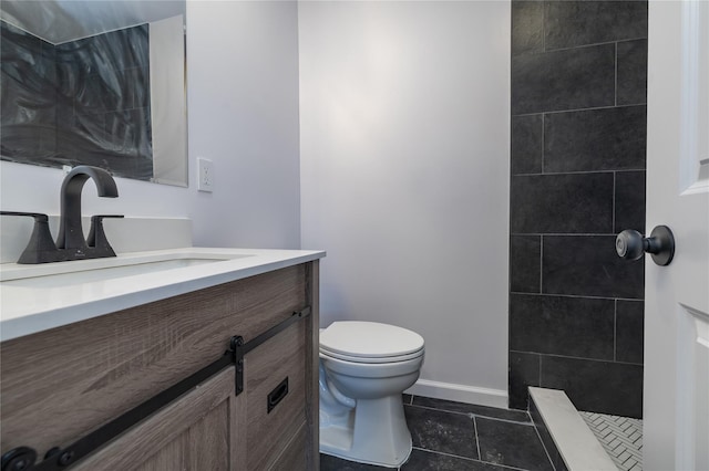 bathroom featuring tiled shower, vanity, toilet, and tile patterned floors