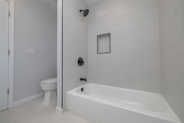 bathroom featuring tiled shower / bath, toilet, and tile patterned flooring