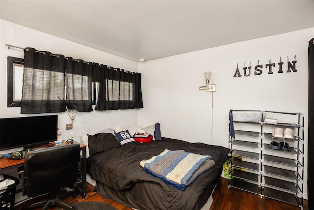 bedroom with dark wood-type flooring