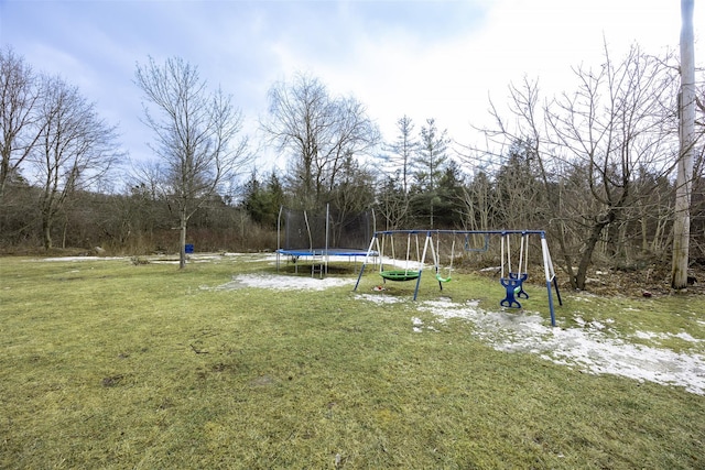 view of yard with a playground and a trampoline