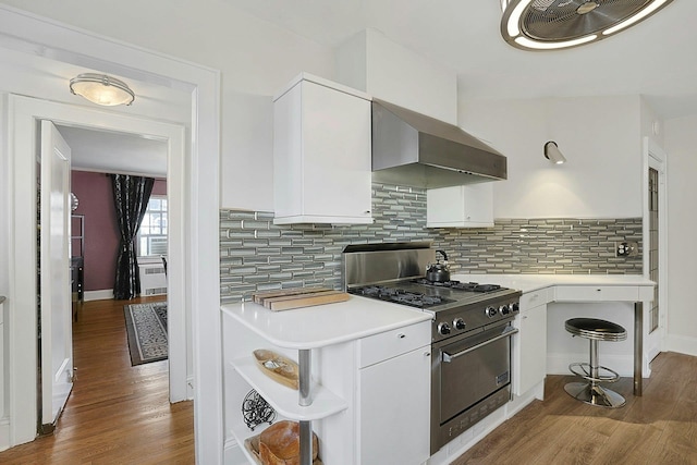 kitchen featuring wood finished floors, white cabinets, wall chimney range hood, high end range, and open shelves