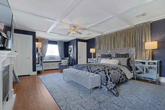 bedroom with coffered ceiling, visible vents, radiator heating unit, and wood finished floors