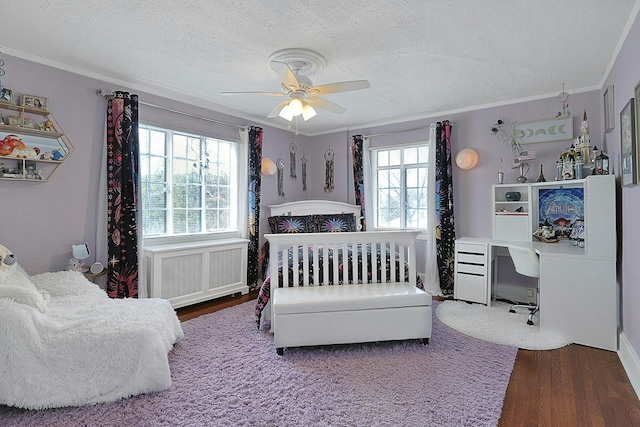 bedroom with radiator, crown molding, a textured ceiling, and wood finished floors