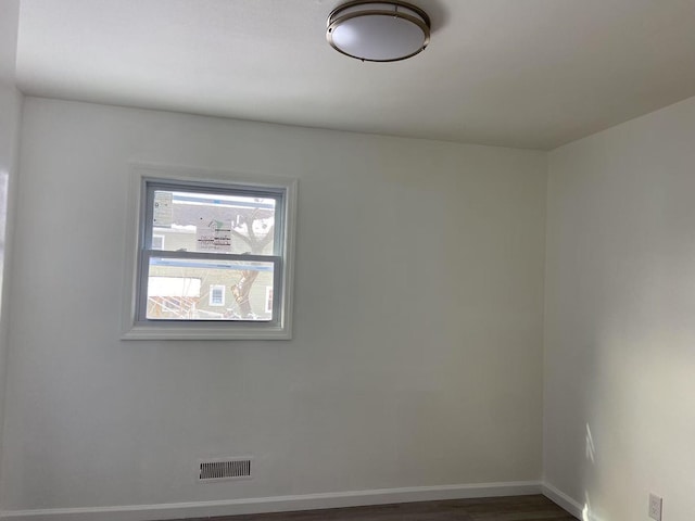 empty room with dark hardwood / wood-style flooring