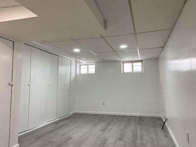 basement with hardwood / wood-style floors and a drop ceiling