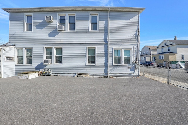 back of property with an AC wall unit and cooling unit