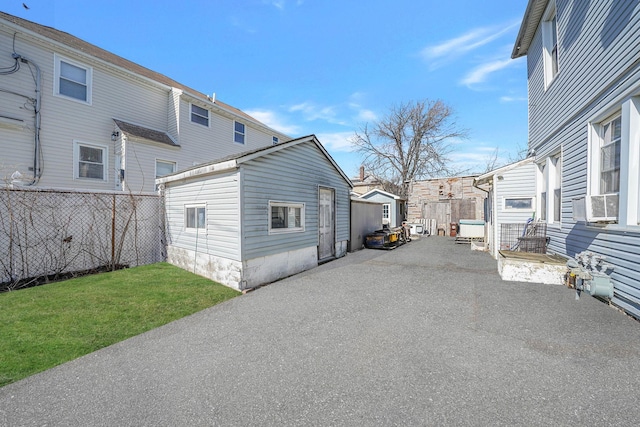 view of side of property with an outbuilding, a patio, and a lawn