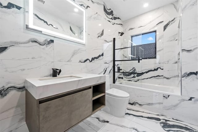 full bathroom with vanity, tiled shower / bath combo, tile walls, and toilet