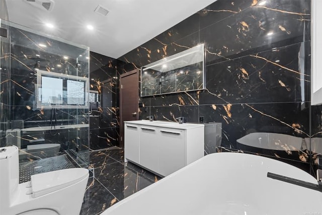 bathroom featuring vanity, a tub, tile walls, and toilet