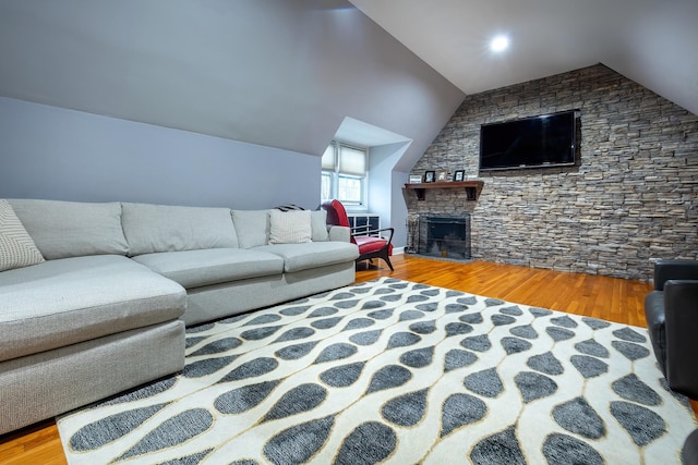 living room with wood-type flooring, lofted ceiling, and a fireplace