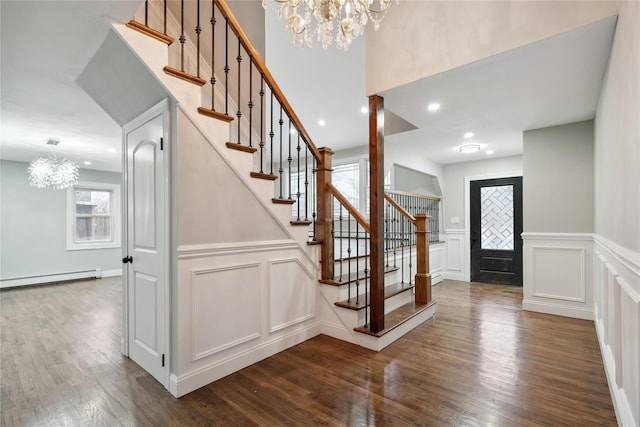 foyer with a notable chandelier, hardwood / wood-style floors, and baseboard heating