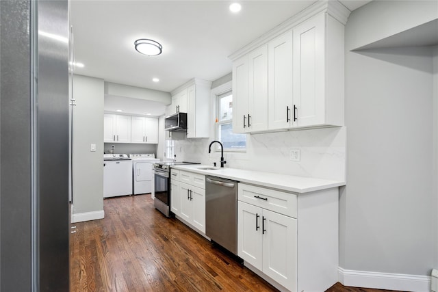 kitchen featuring sink, washer and clothes dryer, white cabinets, and appliances with stainless steel finishes