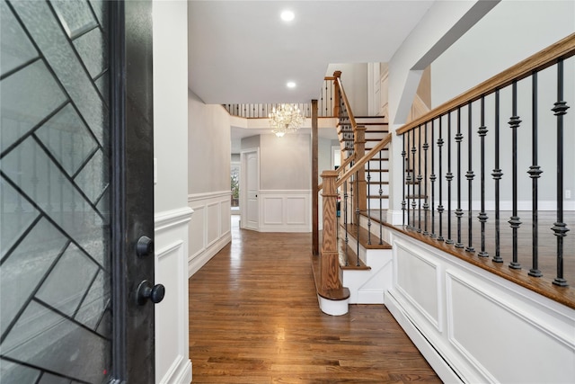 foyer with a baseboard radiator, dark wood-type flooring, and a chandelier