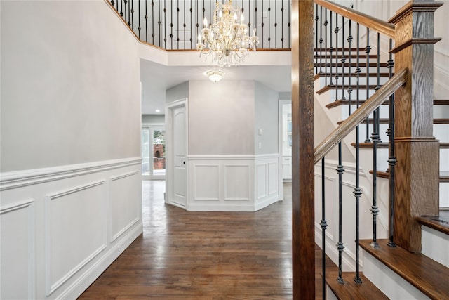 staircase featuring hardwood / wood-style floors and a notable chandelier