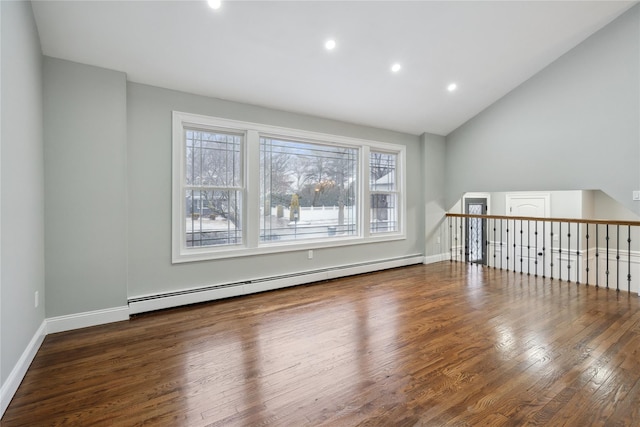 spare room featuring vaulted ceiling, dark hardwood / wood-style floors, and baseboard heating