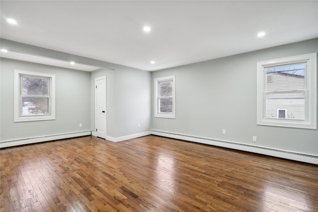 unfurnished room featuring wood-type flooring and baseboard heating