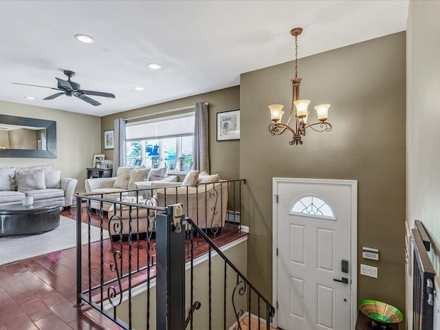 entrance foyer featuring ceiling fan with notable chandelier and dark hardwood / wood-style floors