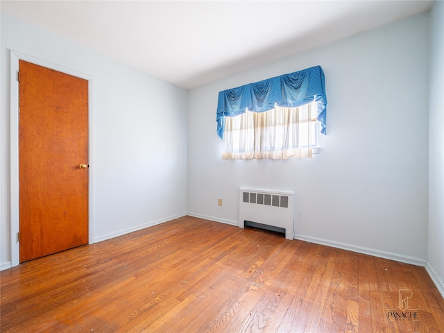 spare room with hardwood / wood-style flooring and radiator heating unit