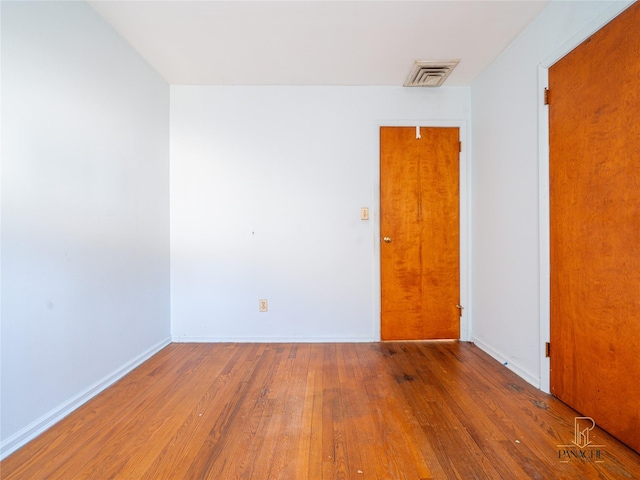 spare room featuring wood-type flooring