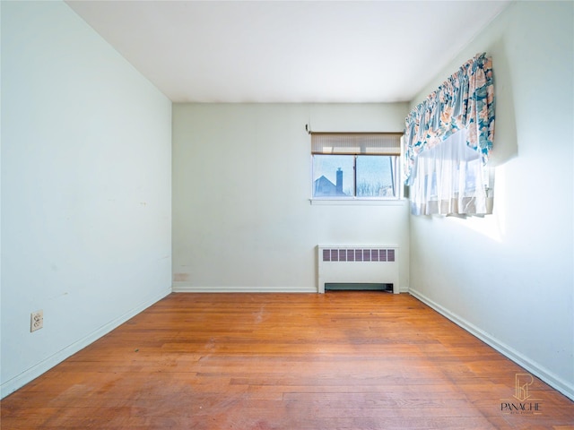 empty room with radiator and light hardwood / wood-style flooring