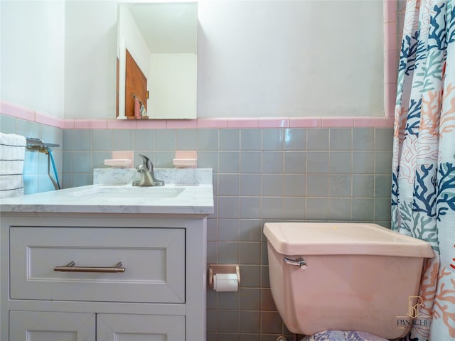 bathroom with tile walls, vanity, and toilet