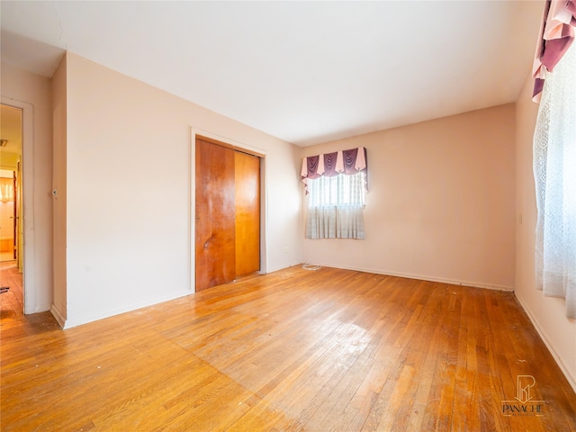 unfurnished bedroom featuring hardwood / wood-style flooring and a closet