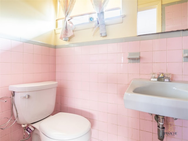 bathroom featuring tile walls, sink, and toilet