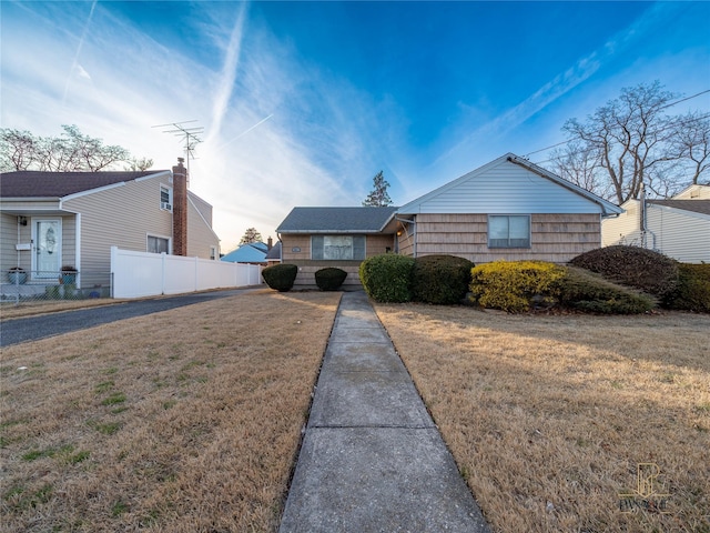 single story home featuring a front lawn