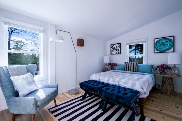 bedroom with vaulted ceiling and wood finished floors