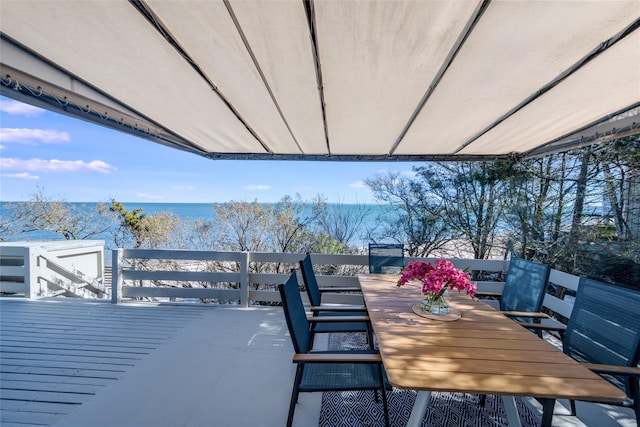 wooden terrace with outdoor dining space and a water view