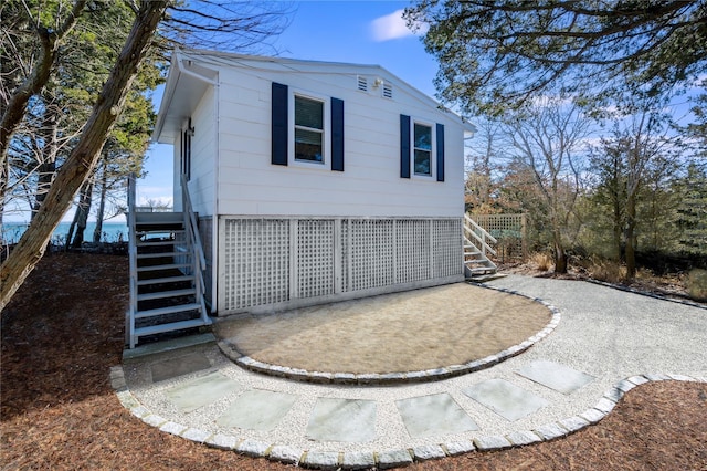 view of home's exterior with a water view and stairs