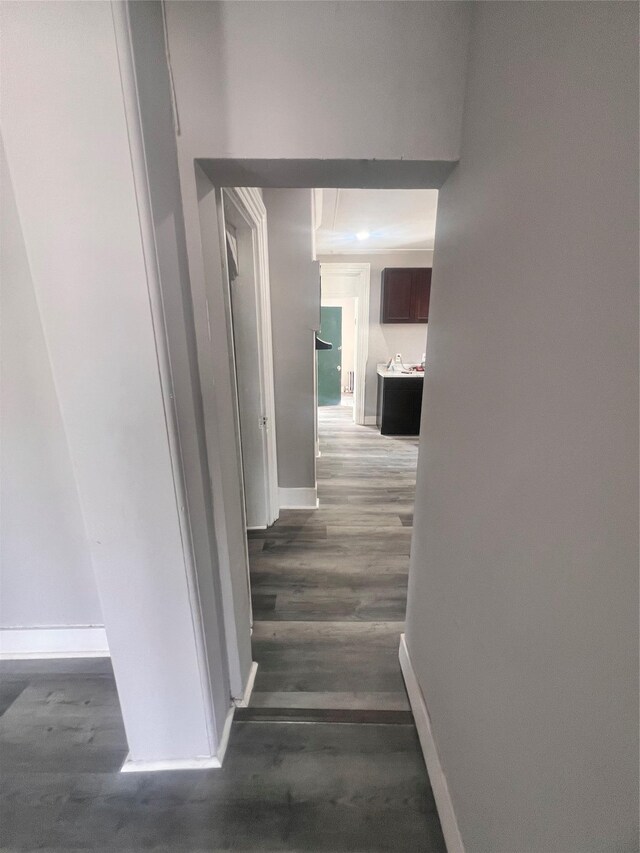 hall featuring baseboards and wood finished floors