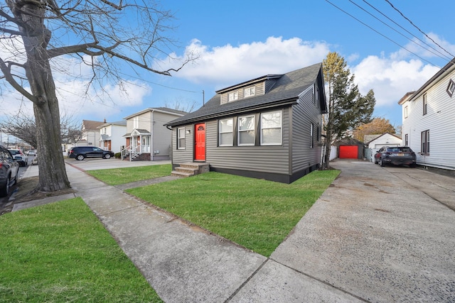 bungalow-style house with a garage and a front lawn