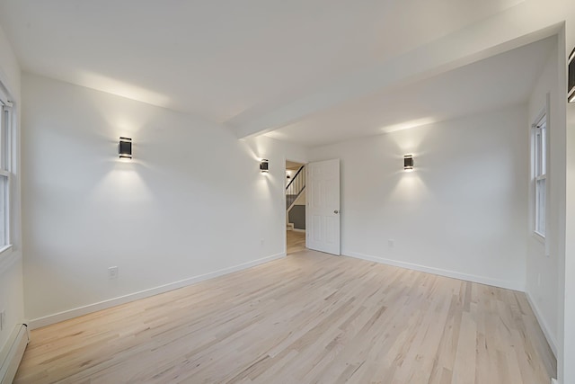 spare room featuring baseboard heating and light wood-type flooring