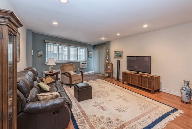 living area featuring baseboards, wood finished floors, and recessed lighting