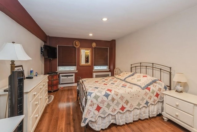 bedroom with dark wood-type flooring, a wall mounted AC, and recessed lighting