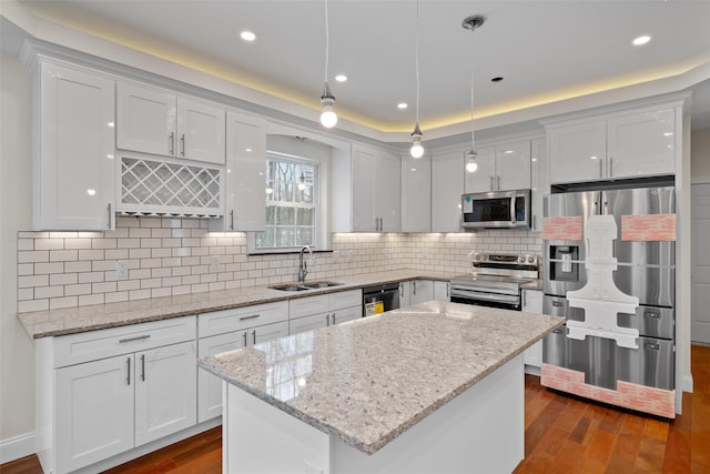 kitchen with appliances with stainless steel finishes, decorative light fixtures, sink, and white cabinets